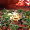 Wood fired pizza topped with fresh rocket, olives and Parmesan shavings