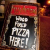 Hand-painted chalkboard reading Wood Fired Pizza Here